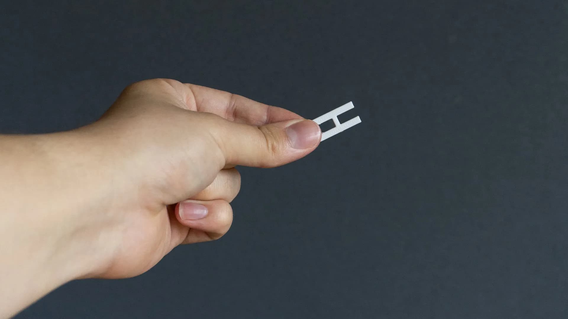 Hand holding the 3D-printed two-pin tool prototype