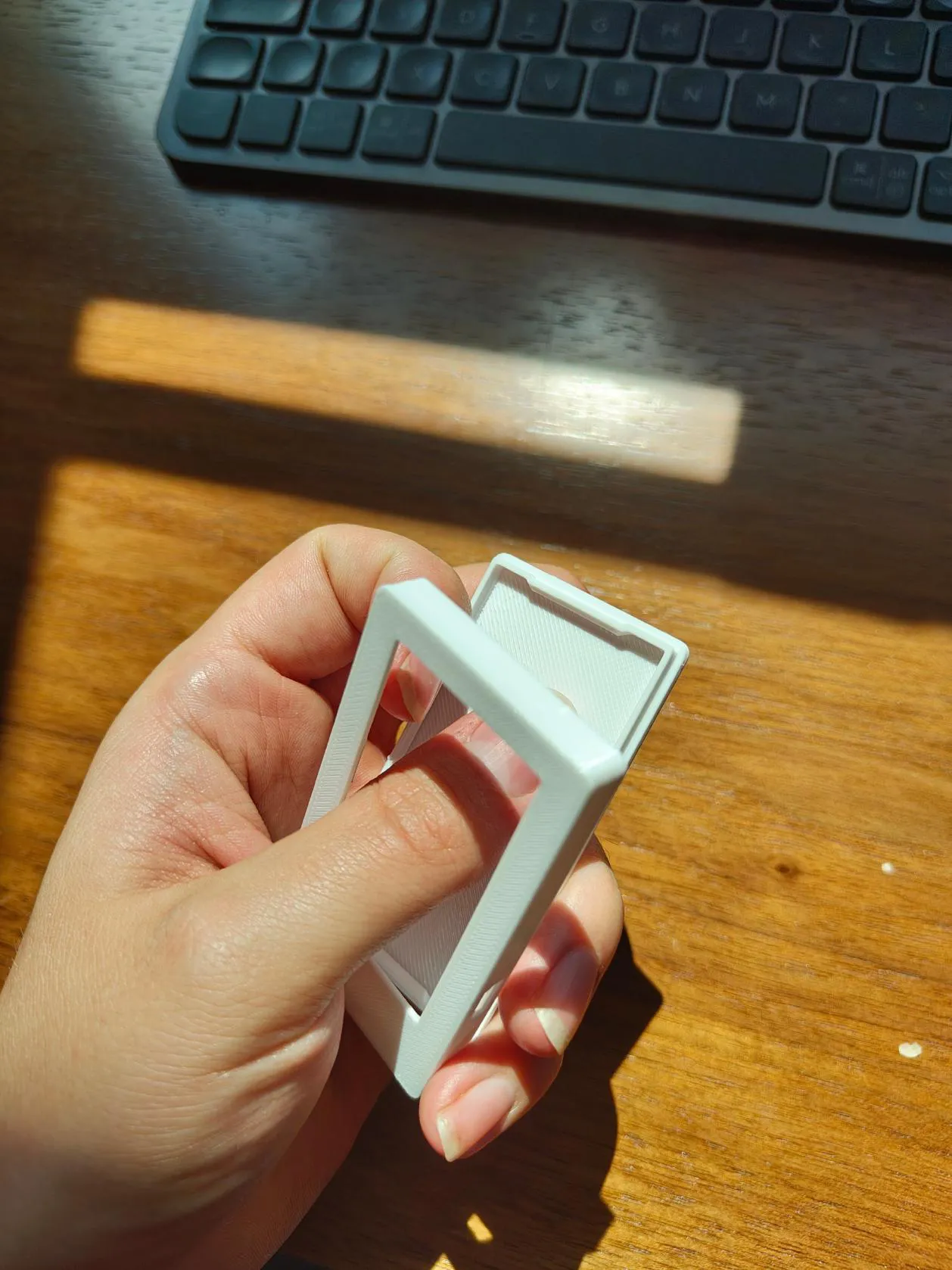 Hands prying apart a 3D-printed snap-fit test part